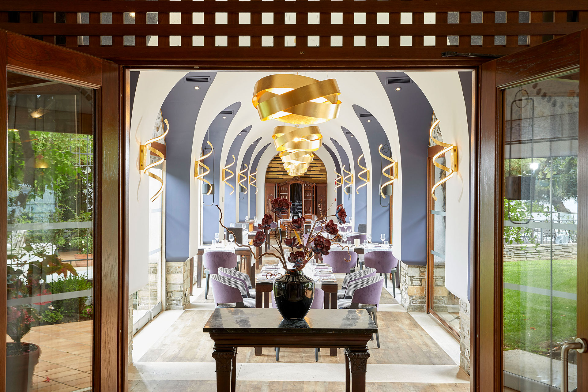 Indoor of Kamares Restaurant fine dining area with arched ceiling and modern golden lighting at Eagles Resort