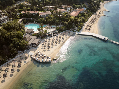 Eagles Resort Chalkidiki sandy beach with trees and umbrellas, and swimming pool