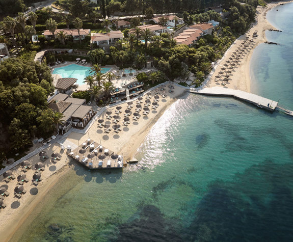 Eagles Resort Chalkidiki sandy beach with trees and umbrellas, and swimming pool