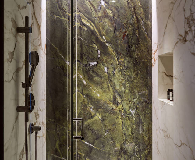 Executive junior suite's marble shower with green wall feature at Eagles Palace