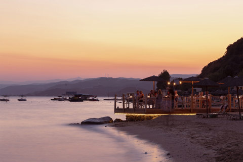 Beachfront dining at sunset with guests enjoying dinner by the sea at Armyra restaurant in Eagles Resort