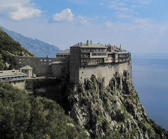 View of a historic cliffside monastery on Mount Athos overlooking the sea 