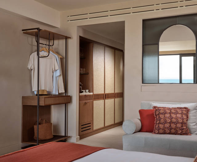 Executive junior suite with open wardrobe, sofa with cushions and a kitchenette at Eagles Palace