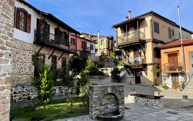 Arnea traditional village square with stone-paved streets and wooden-balcony houses