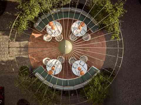 Aerial view of circular outdoor dining area with modern tables at patio bistro in Eagles resort