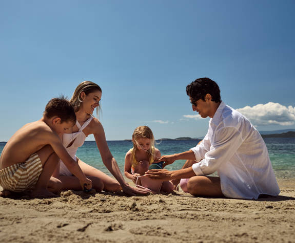 Family playing with the sand at the beach at Eagles Resort