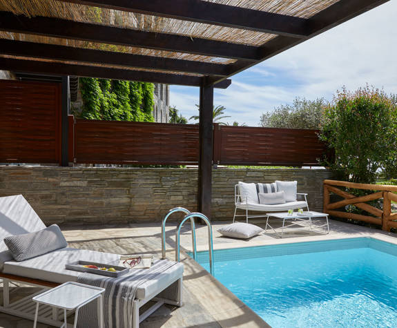 Suite's private pool terrace with sunbed under wooden pergola and sitting area at Eagles Palace