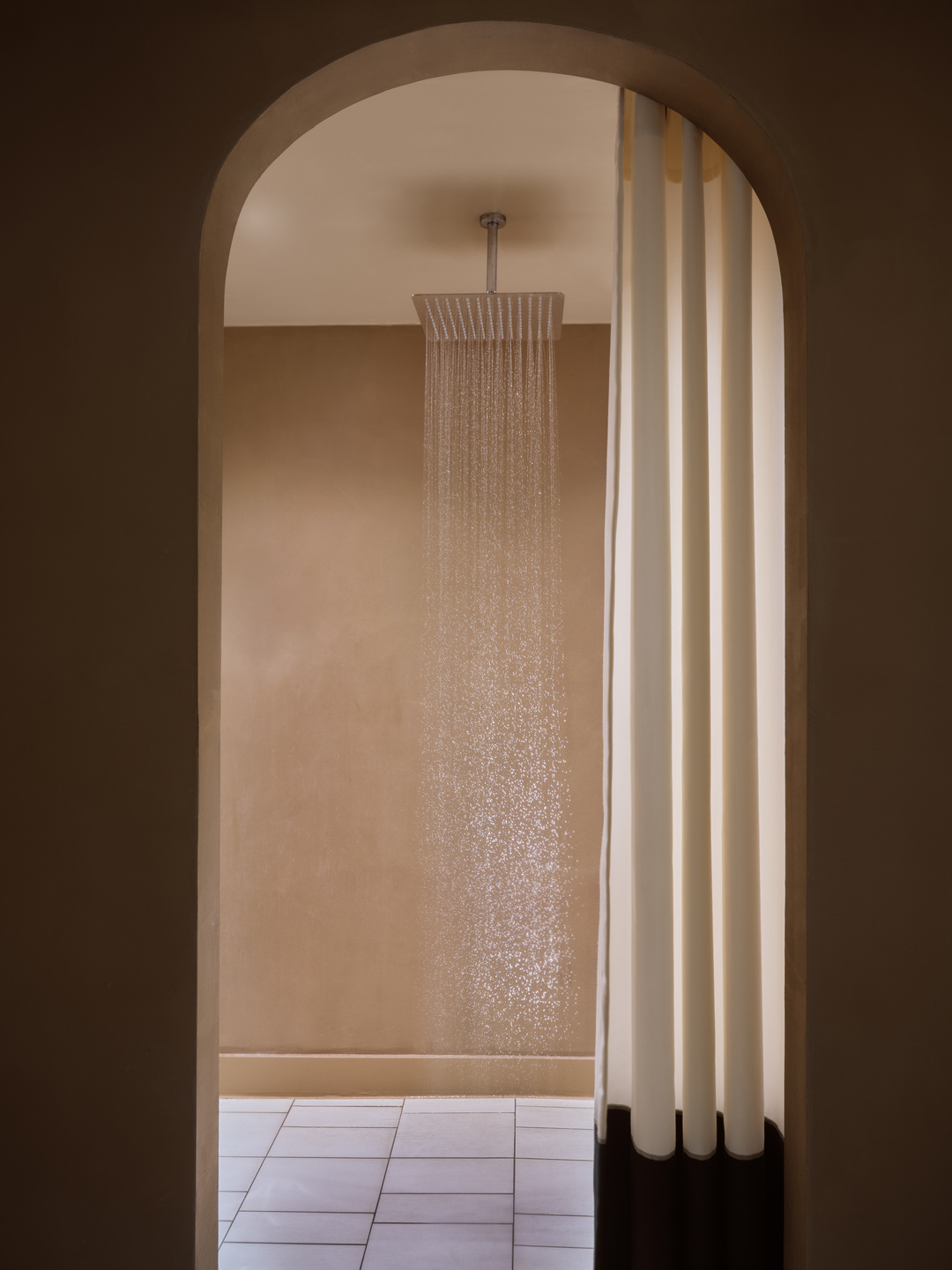 Arched-entry bathroom in a bungalow with ceiling-mounted rain shower in Eagles Palace