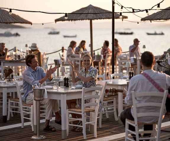 Guests enjoying seaside dining with live music at sunset in Armyra restaurant at Eagles Resort