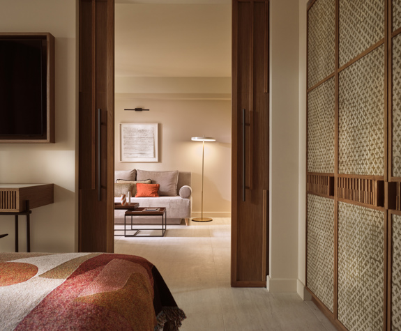 Deluxe suite at Eagles Palace with sliding wooden doors, sofa seating and a floor lamp in the living area