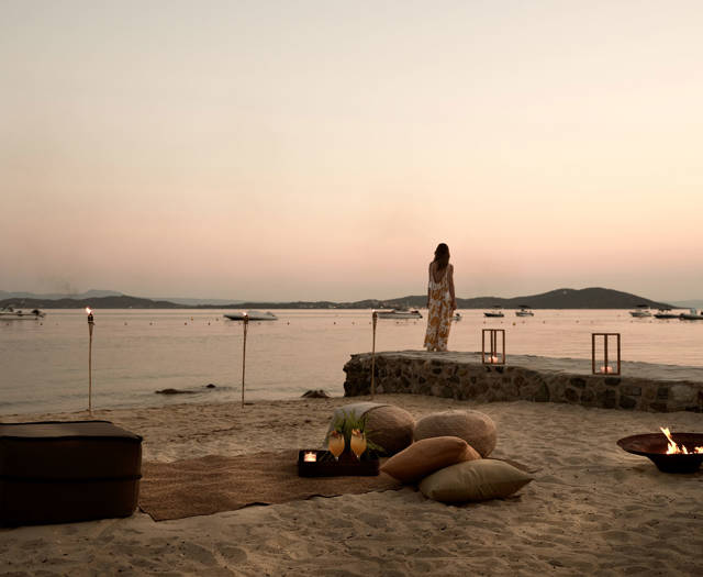 Romantic beach lounge setup at sunset with cushions, firepit, and a sea view at Eagles Resort