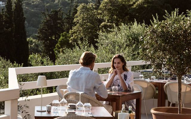 Couple dining on the olive-tree-shaded terrace of Eleonas restaurant at Eagles resort