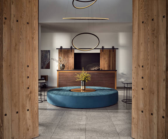 Reception area with round blue bench, wooden accents and modern ring lighting at Eagles Resort
