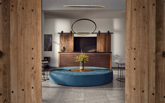 Reception area with round blue bench, wooden accents and modern ring lighting at Eagles Resort