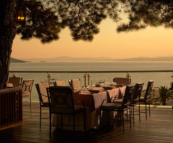 Eagles Resort Chalkidiki Kamares Restaurant tables under the pine trees, at the sunset